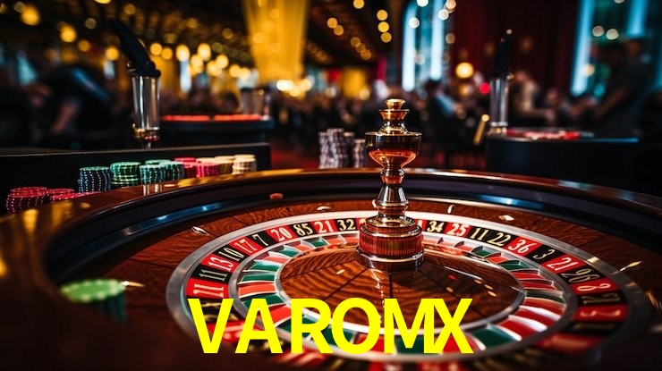 Una escena digital vívida inspirada en casino con VAROMX mostrado prominentemente, luces brillantes, fichas, cartas y acentos dorados.